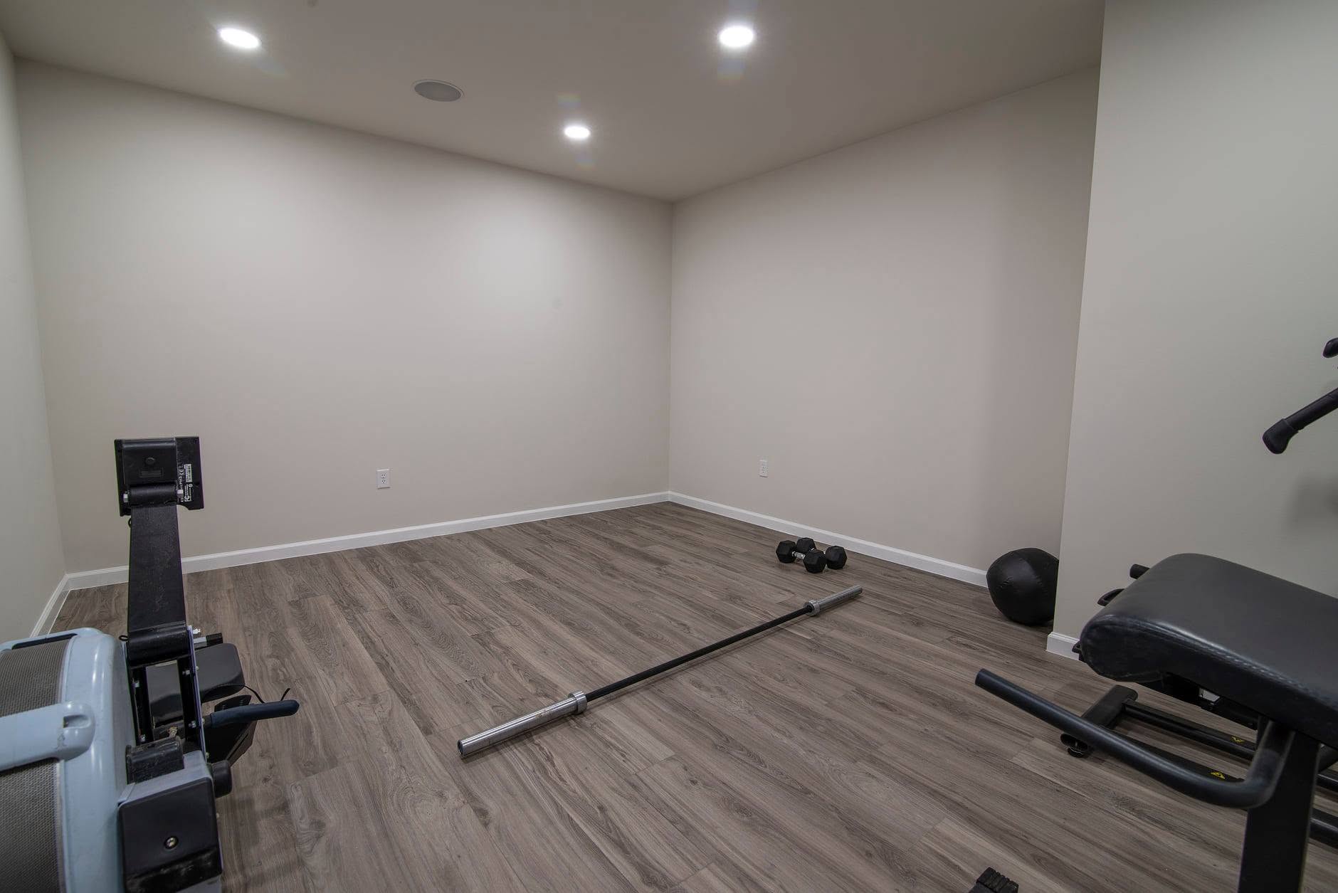 After: finished room with a plank floor and recessed lighting