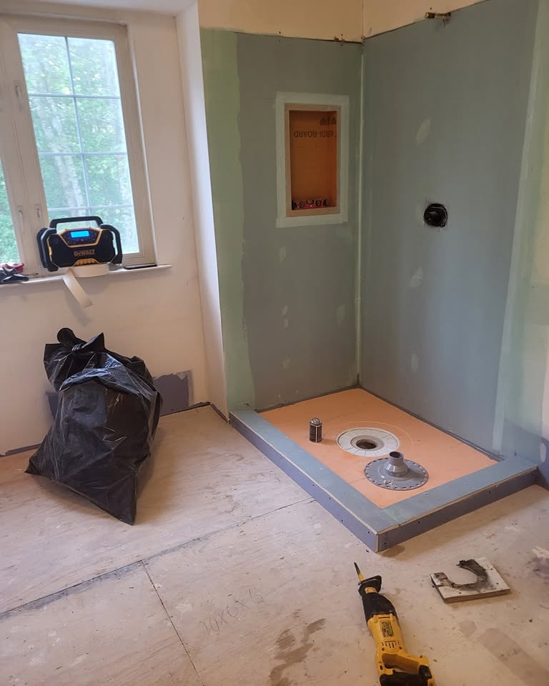 Before: shower corner in bare cement board, with a recessed niche