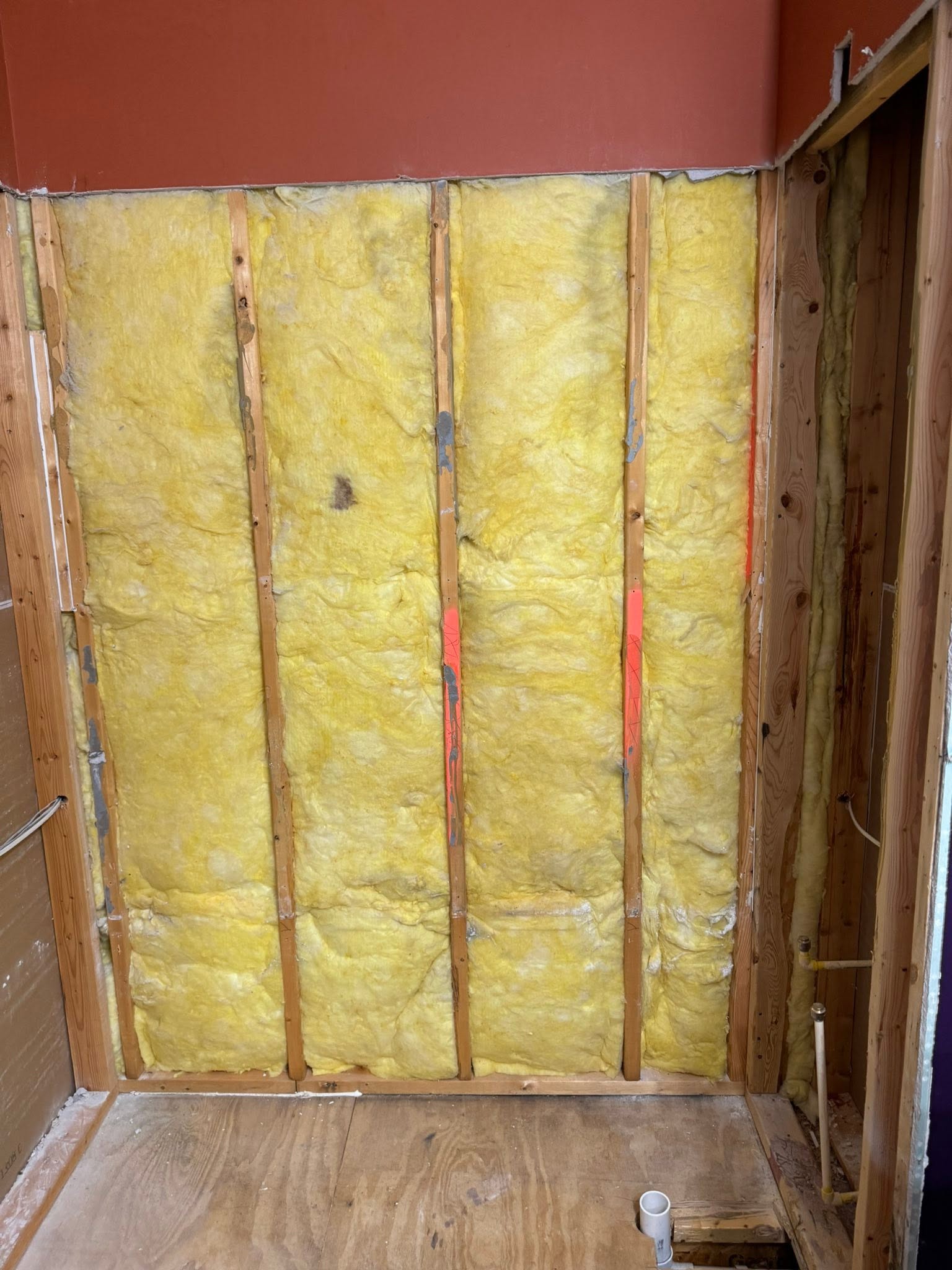 Before: bathroom wall opened to insulated studs