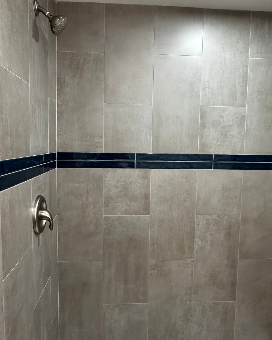Shower · large-format tile with a navy accent band